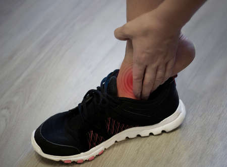 Young woman massaging her painful foot from exercising and running Sport and excercise concept....