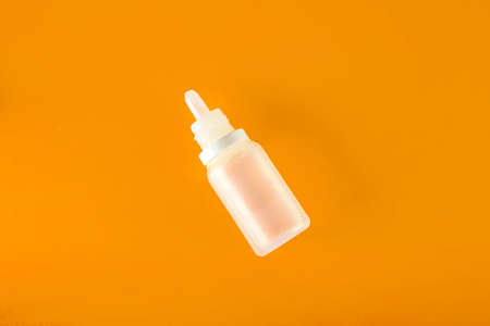 White plastic nasal spray on orange background - sinusitis, geniantritis, rhinitis and other...