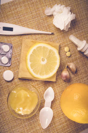 Treatment of colds and flu. Various medications, cold pills, throat spray, nasal drops, and a paper napkin on a brown background. Treatment of influenza. Medicine flat layの写真素材