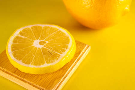Fresh sliced lemon on yellow background. Lemons fruits. Juicy slice of lemon on yellow background.