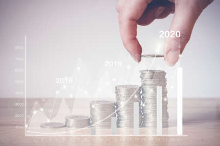 Hand putting money coin on line rising, virtual hologram statistics, graph and chart with arrow up...