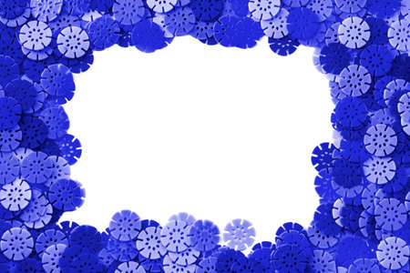 Blue frame designer background. Multi-colored details in the form of snowflakes from the children's designer On White Background. plastic discs for the development of fine motor skills of fingersの写真素材