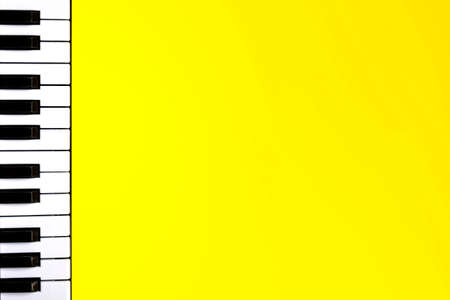 Top view piano keys over yellow background. Pianist musician, pianist concept. Music Keyboard. Copy spaceの写真素材