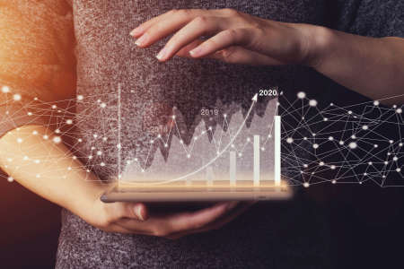Business woman are checking stock market graph with arrow up on light background by using tablet....