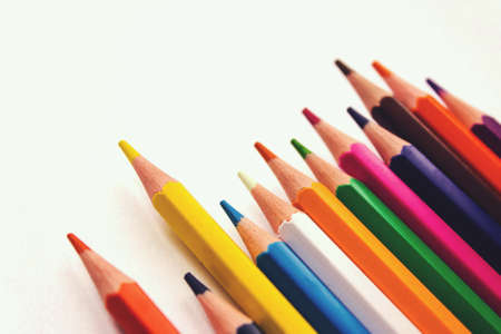 School notebook, Colored pencils in row on white backgroundの写真素材