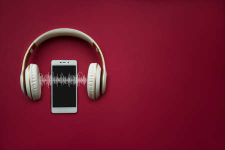 Modern cell White phone and headphones template on red gradient background with Audio track. Music conceptの写真素材