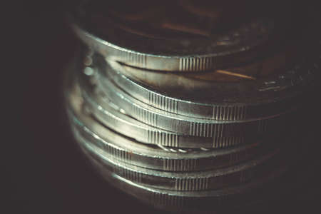 Coins stacked on each other in different positions on dark background. Money concept. Closeup. Money and saving concept. Success, wealth and poverty, poorness concept. Business Growth conceptの写真素材
