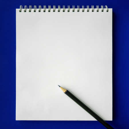 School notebook and pencil on blue background, back to school concept, modern elementary education....