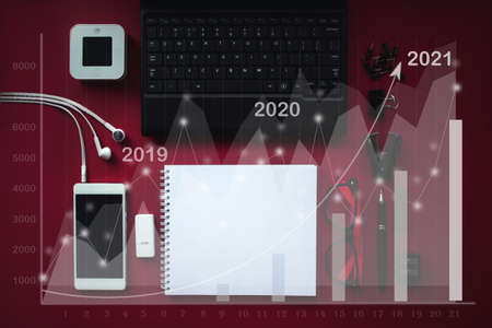 Mix of office supplies and gadgets with virtual hologram stat, graph. Investment ideas. Success