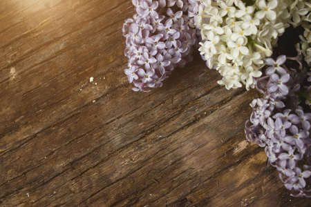 Bouquet of lilac flowers and Lily of the valley on a shabby wooden background. Vintage floral background with spring flowers. Copy spaceの写真素材