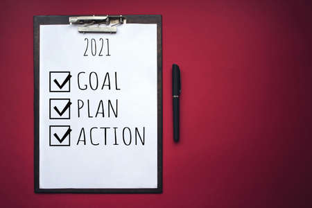 Mock up of wooden clipboard with blank paper and text goal, plan, action on red background. Concept...