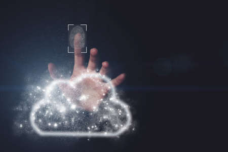 Data cloud on the hand, dark background. Hand click on fingerprint computing icon. Protect Cloud Computing Data. fingerprint scanning technology. Fingerprint to identify personal, security system conceptの写真素材