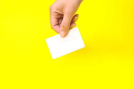 hand holding business card, mockup, on yellow backgroundの写真素材