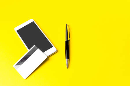 Smartphone, Business Card and Pen on Yellow background. Online shopping. Online paymentの写真素材