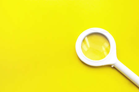 High Angle View Of Magnifying Glass Over Yellow Background. Magnifying Glass - Search Engine Optimizationの写真素材