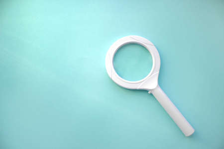 High Angle View Of Magnifying Glass Over Blue Background. Search. Magnifying Glass - Search Engine Optimizationの写真素材