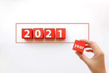Hand arranging red blocks stacking on line with text 2021 year. Business concept for growth success processの写真素材