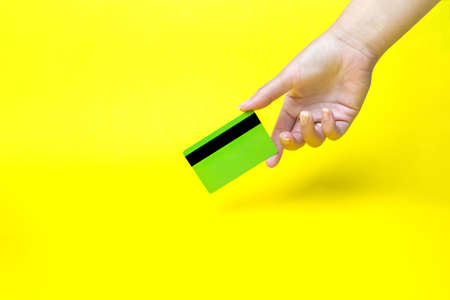 Hand holding business card, mockup, on yellow backgroundの写真素材