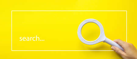 Hand Holding Magnifying Glass Against White Background with the text Search. Business creativityの写真素材