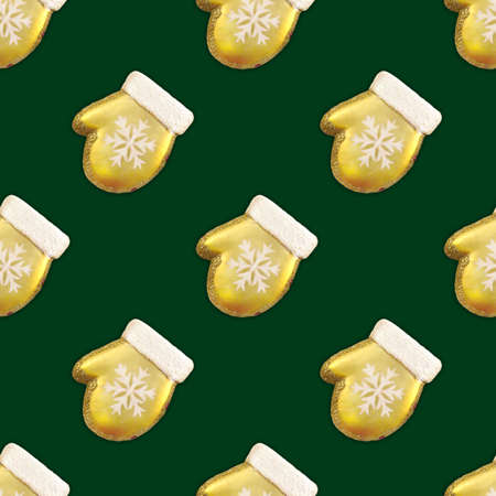 Seamless pattern of Gold Christmas Mitten With White Snowflake on green background. for holiday...
