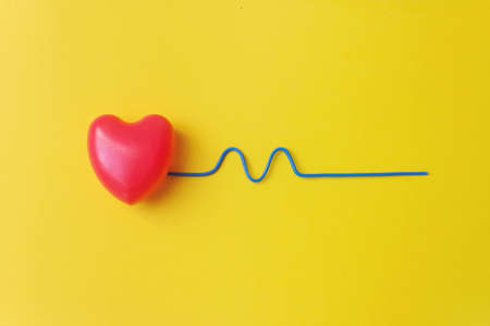 Red heart with a blue curved wire depicting a heartbeat. Healthy Concept. Vital energy concept