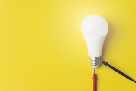 Glowing bulb with multimeter probes on yellow background, uniqueness concept. Idea, innovation,...