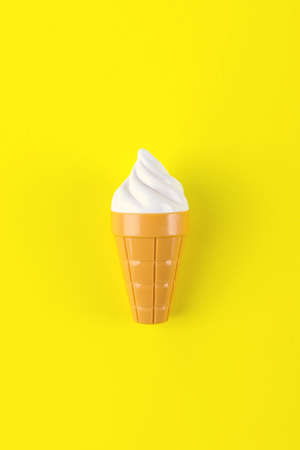Close-up of a plastic ice-cream on yellow backgroundの写真素材