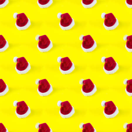Santa's red hat seamless pattern on yellow background