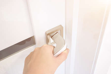 Close-Up Of Hand Opening Door. Hand Holding Chrome Doorknob.