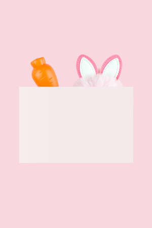 Ears of an Easter bunny and carrot on pink background. Easter letter background. Spring holiday...