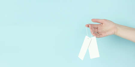 Girl holding badge with price tag on blue background. Copy space