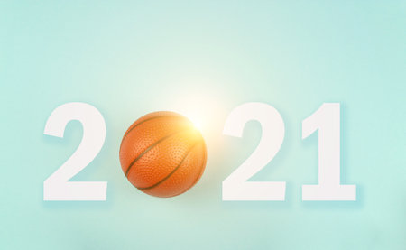 Small orange ball for basketball sport game on blue background with text 2021 and sunshineの写真素材