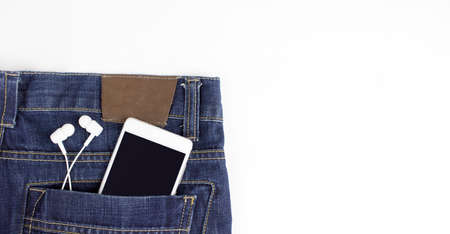 Smartphone with empty blank screen and headphones in back pocket jeans.の写真素材