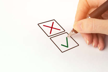 Hand with black pen choosing one of two options answer. Person Marking in a Checkbox