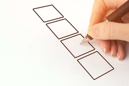 Hand with pen and check boxes on white background