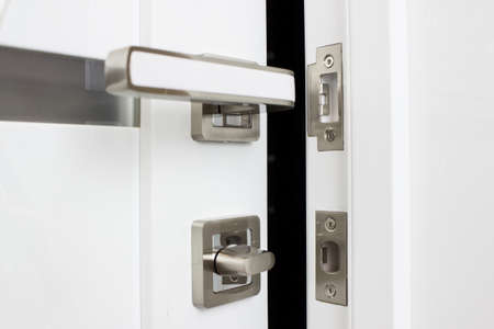 Modern, contemporary satin handle. Modern white door with chrome metal handle.