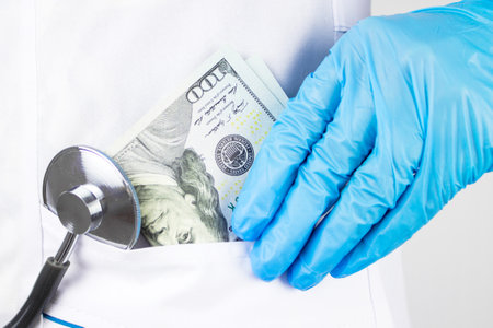 Woman doctor took money. The Corruption concept. Doctor hand with money. Doctor hand putting money into his pocket.の写真素材