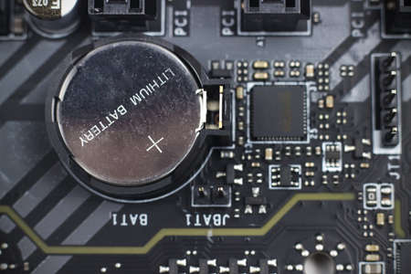Information engineering component. Part of modern computer circuit board with battery computer...