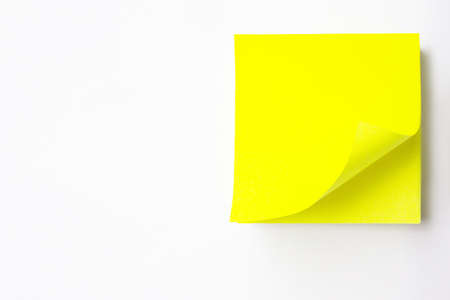 Close-up of a yellow blank sticker A White Background. Empty Yellow note With Black Pin on White Yellow Background. Blank yellow sticky note.の写真素材