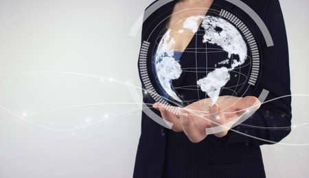 Global network concept. Hand hold digital hologram digital planet on gray background. Concept on business, politics, ecology and media, representing global technologies concept.の写真素材