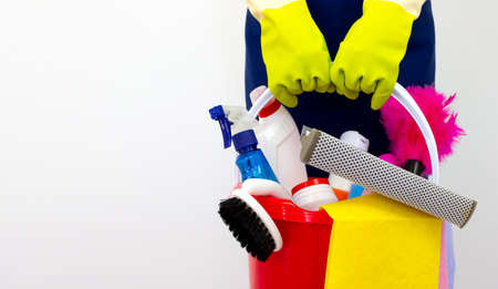 House cleaning products pile in hand with green gloves on white background. Consept cleaning...