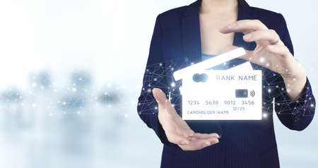 Online payment digital and shopping on network connection. Two hand holding virtual holographic credit card icon with light blurred background. Online shopping or internet shop concepts.の写真素材