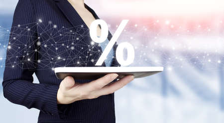 Discount and commission concept represented by percentage sign. Hand hold white tablet with digital...