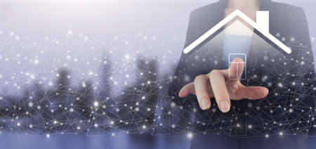 Smart home Automation Control System. Hand touch digital screen hologram Smart Home sign on city light blurred background. Real estate agent offer house, property insurance and security.の写真素材