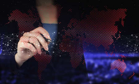 Hand holding digital graphic pen and drawing digital hologram world, earth, map, globe sign on city...