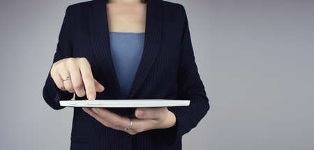 Automation Software Technology Process System Business concept. White tablet in businesswoman hand with digital hologram icon sign on gray backgroundの写真素材