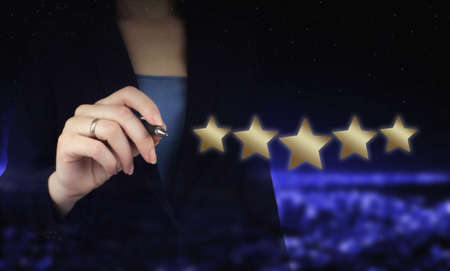 Hand pointing five star symbol to increase rating of company. Hand holding digital graphic pen and...