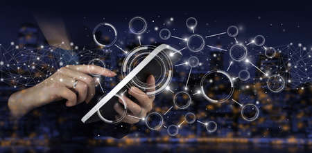 Automation Software Technology Process System Business concept. Hand touch white tablet with digital hologram circular diagram sign on city dark blurred background. Big data visualization futuristicの写真素材