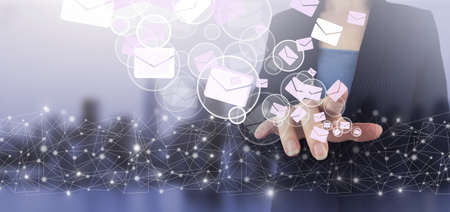 Email and sms marketing concept. Hand touch digital screen hologram Email and sms sign on city light...