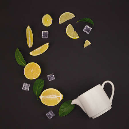 Summer Fresh organic yellow lemon lime fruit drink tea with green leaves and chamomile flower on brown backgroundの写真素材